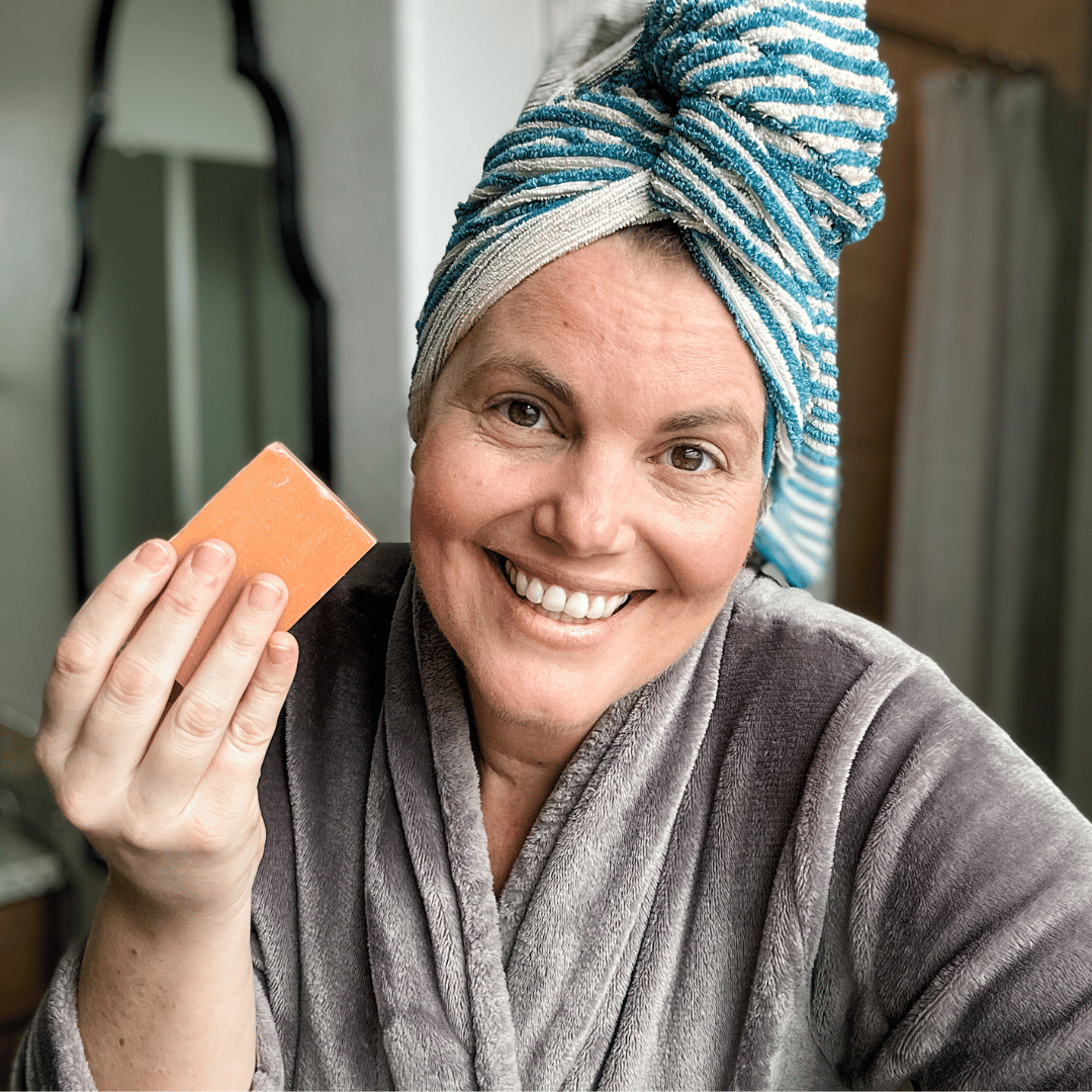 Woman holding Mirai Clinical's Deodorizing Soap infused with Japanese Persimmon, targeting nonenal body odor