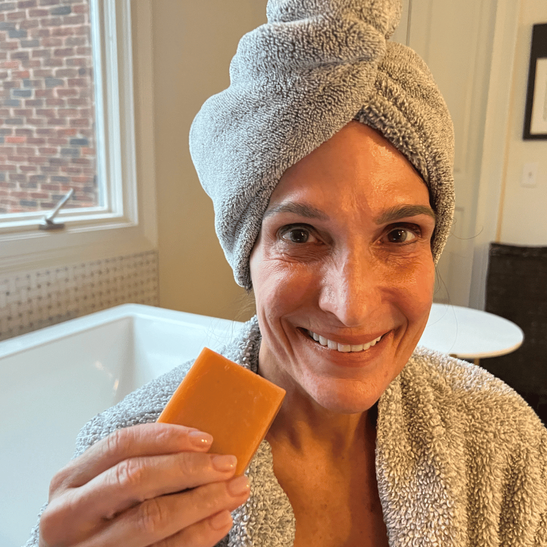 Woman holding Mirai Clinical's Deodorizing Soap infused with Japanese Persimmon, targeting nonenal body odor