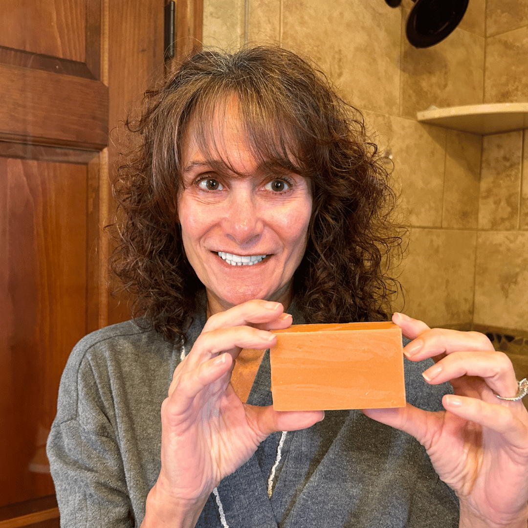 Woman holding Mirai Clinical's Deodorizing Soap infused with Japanese Persimmon, targeting nonenal body odor