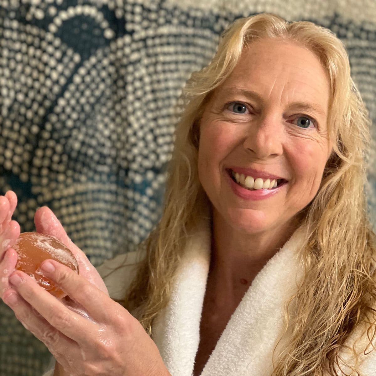 Joyful customer showcasing Mirai Clinical's soap, indicating their contentment with its deodorizing properties and skin benefits.