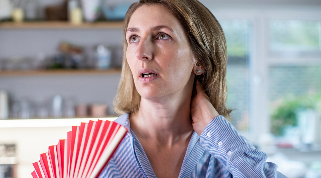 Woman fanning herself during a hot flash