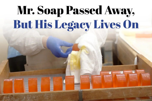 Gloved worker in a Japanese factory hand-polishing rows of translucent orange persimmon soap bars on a wooden rack