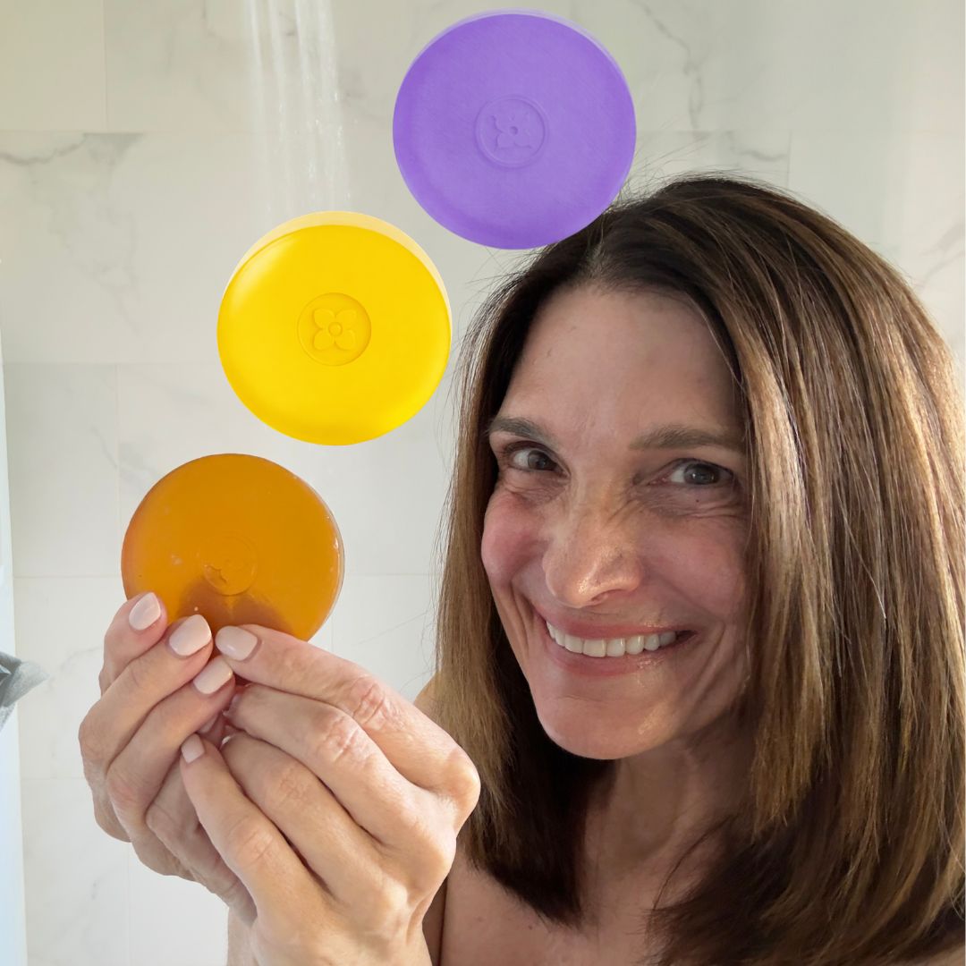 Woman holding Mirai Clinical persimmon deodorizing soap bars in lavender and citrus scents designed to help eliminate nonenal aging body odor.