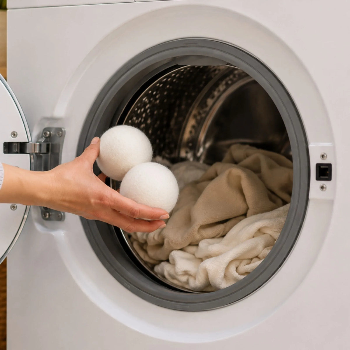 Wool dryer balls tumbling with clothes inside a dryer to reduce static, soften fabrics naturally, and speed up drying.