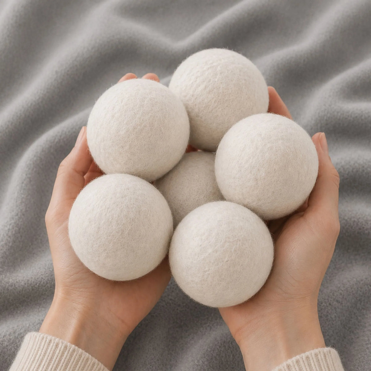 Hand holding six premium wool dryer balls for chemical-free fabric softening, wrinkle reduction, and faster drying.