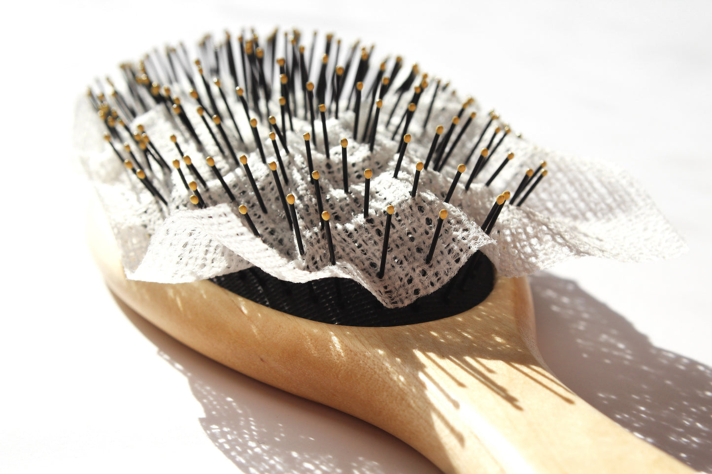 Close-up view showcasing the intricate details of Mirai Clinical's hair brush and its accompanying liner, emphasizing their design for effective hair grooming and optimal scalp care.