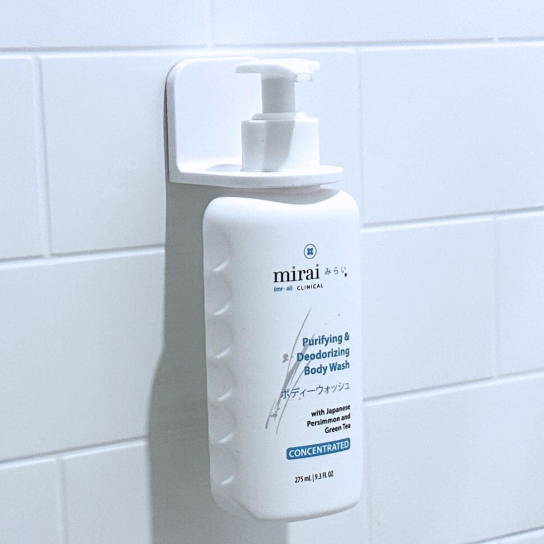 Mirai Clinical body wash secured in wall-mounted holder for convenience.