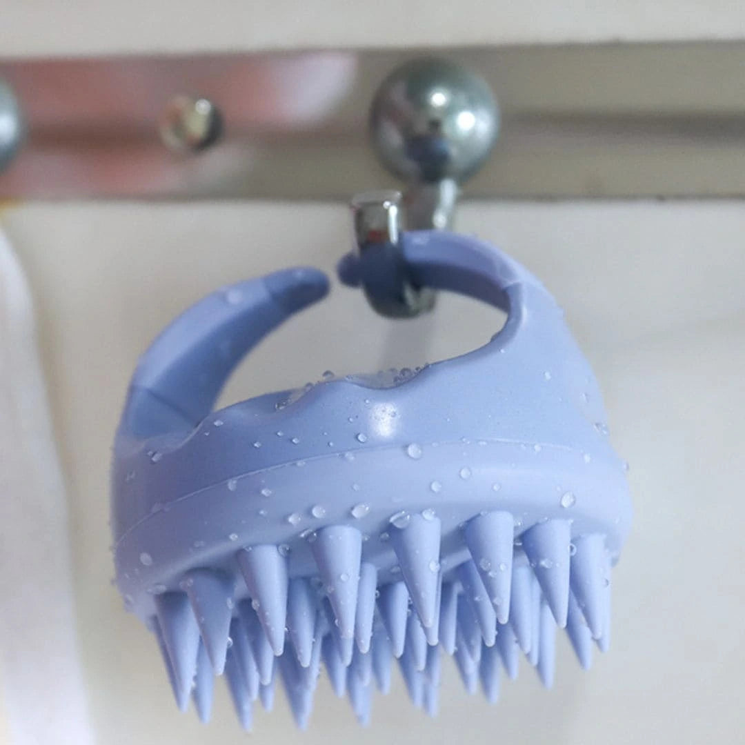 Mirai Clinical Scalp Massager hanging, showcasing its ergonomic design and silicone bristles.