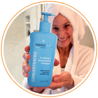 Woman in bathrobe holding Mirai Clinical Purifying & Deodorizing Shampoo.