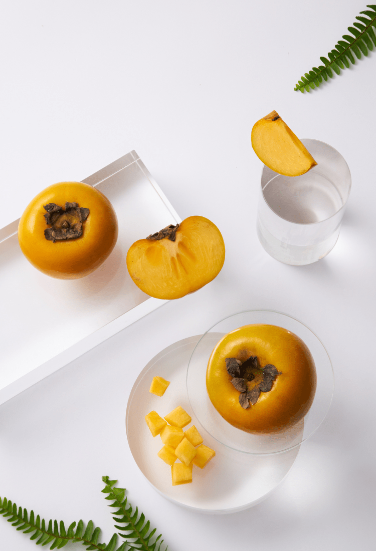 A vibrant display of fresh Japanese persimmons with a rich orange hue, arranged neatly and ready for consumption.