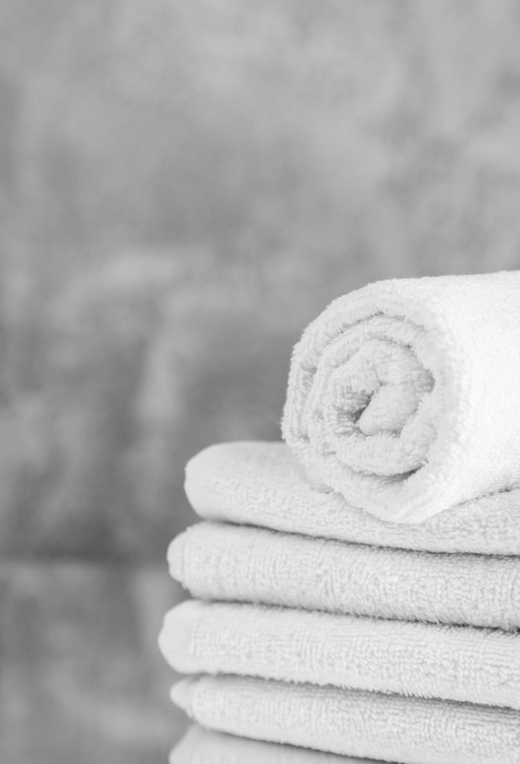 A fresh, clean white towel neatly hanging on a metallic rack, suggesting hygiene and comfort
