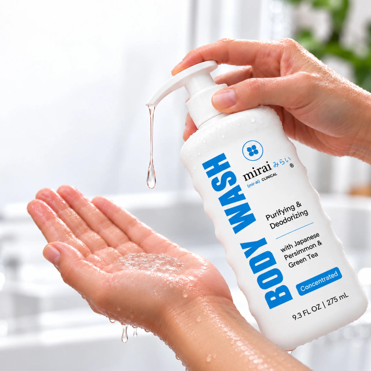 Wet hands pumping Mirai Clinical Purifying & Deodorizing Body Wash with Japanese Persimmon & Green Tea, a concentrated 9.3 fl oz formula, into an open palm in a bright bathroom.