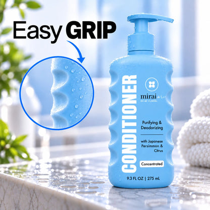 Mirai Clinical Purifying & Deodorizing Conditioner with Japanese Persimmon & Citrus on a wet bathroom counter, with a close-up of the finger grooves on the side of the bottle. Text: Easy grip.