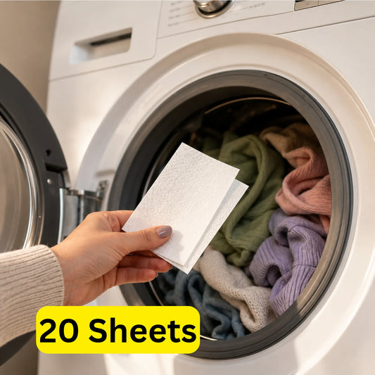 Hand placing a Mirai Clinical Persimmon Dryer Sheet into a front-loading machine filled with clothes. Text: 20 sheets.