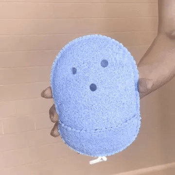 Close-up of blue body scrub being held, demonstrating its use for exfoliation and deep cleansing.
