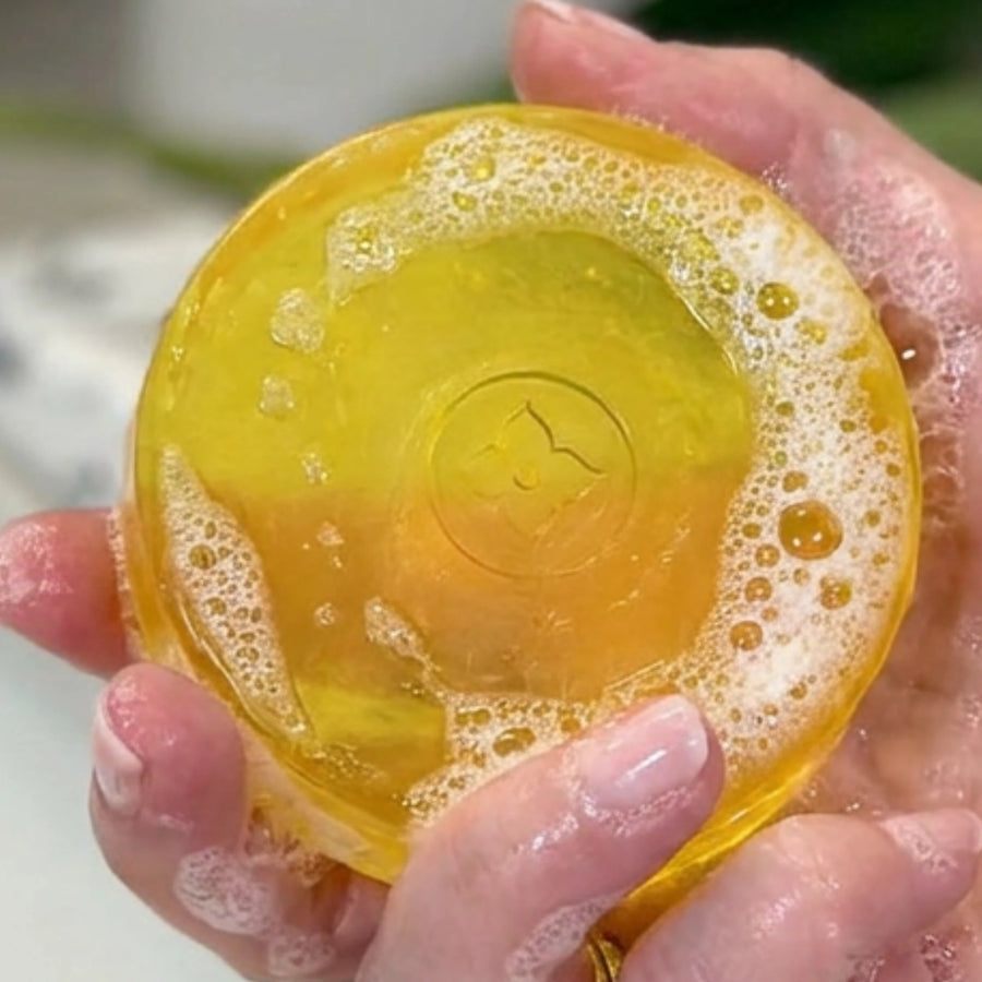 Hands holding citrus deodorizing soap with rich lather designed to cleanse skin and eliminate Nonenal aging odor naturally.