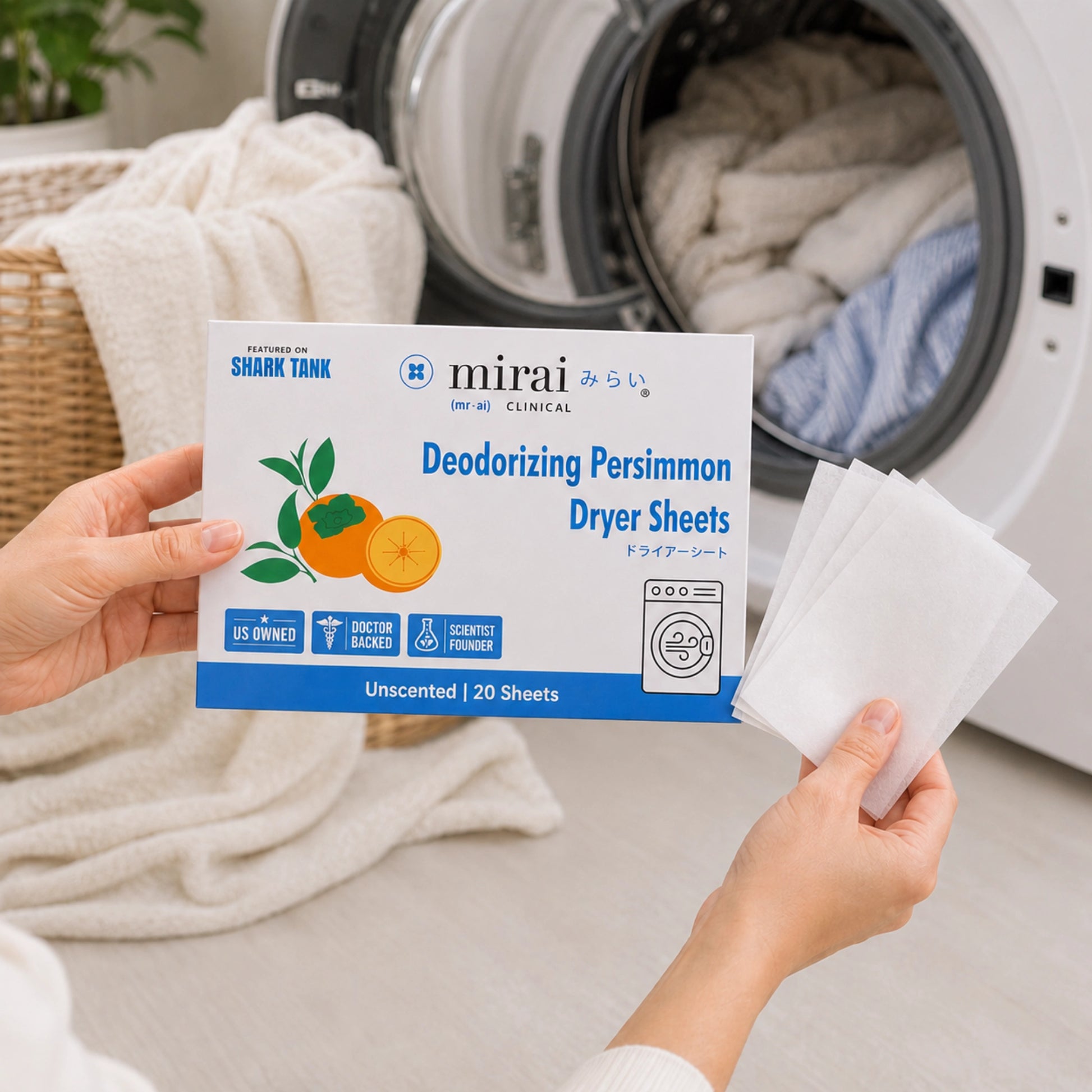 A person holds a package of Mirai Shark Tank Deodorizing Persimmon Dryer Sheets next to an open washing machine with laundry inside, showing the white sheets being dispensed.
