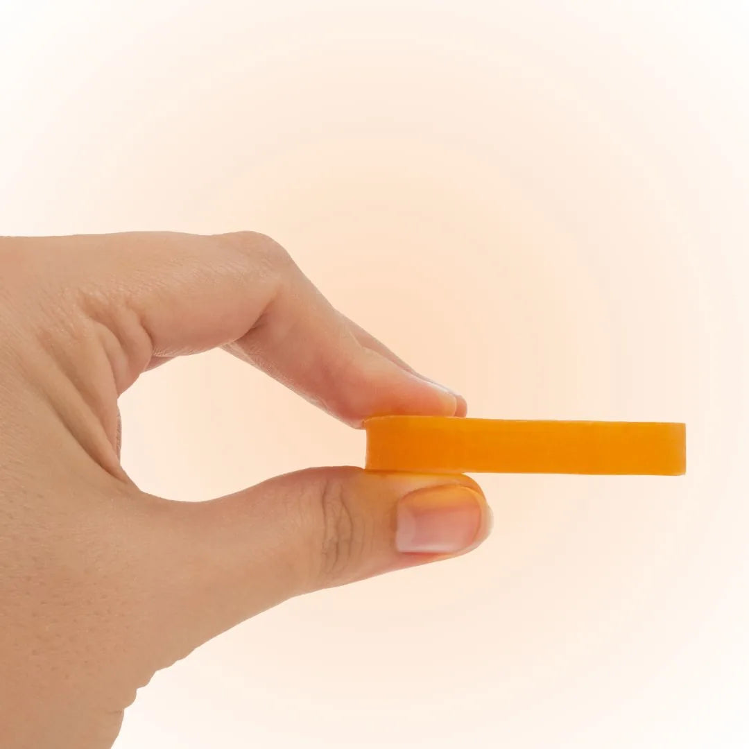 Hand holding a thin Mirai Clinical Nonenal deodorizing mini soap bar showing its compact travel-friendly size