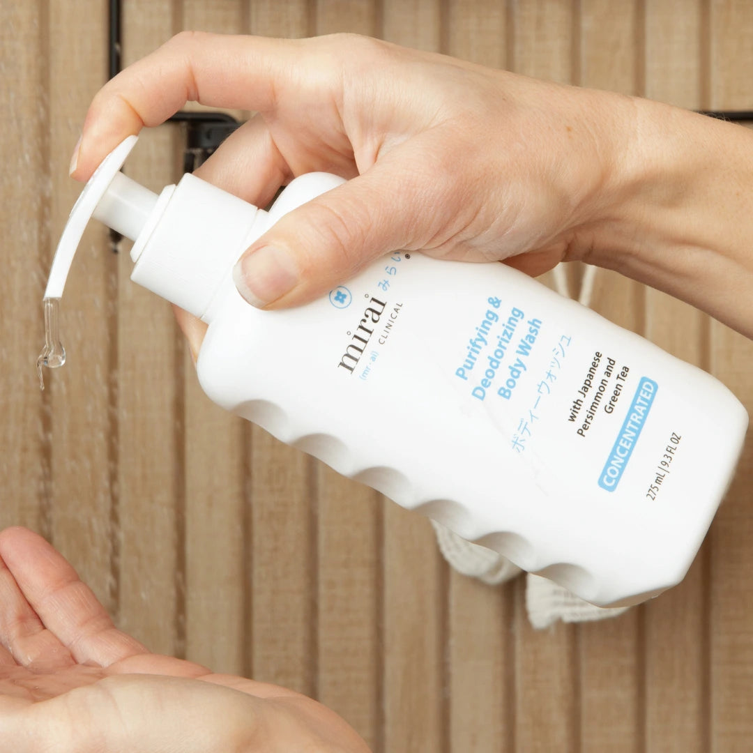 Two hands holding Mirai Clinical persimmon body wash
