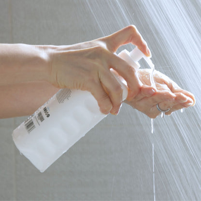 Close-up of Mirai Clinical body wash being dispensed onto hand under shower water, designed to neutralize Nonenal body odor and keep skin fresh.