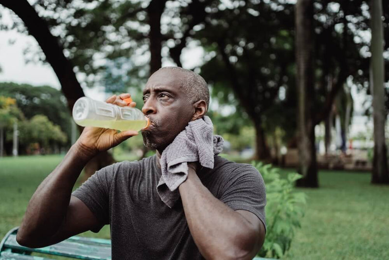 Man drinking water from a plastic bottle.