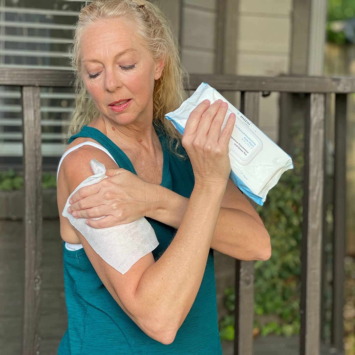 Woman using Mirai Clinical's Deodorizing Body Wipes with Japanese Persimmon to combat nonenal body odor.
